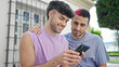 © Krakenimages.com - Two men couple smiling confident using smartphone at street