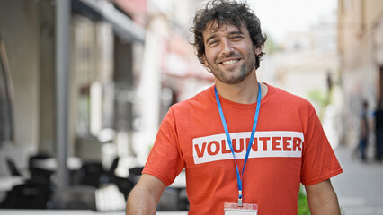 Poster - Young hispanic man activist wearing volunteer uniform smiling at street