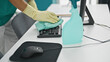 © Krakenimages.com - Young hispanic man cleaning keyboard with a cloth at office