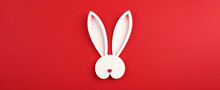 Easter greeting card with white paper cut Bunny Ears isolated on a red background,