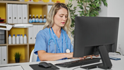 Poster - Young blonde woman doctor using computer working at clinic