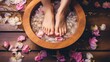 Woman soaking her feet in bowl with water, stones and flowers on wooden floor. Pedicure procedure or feet spa concept.