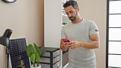 Sticker - Young hispanic man business worker using smartphone at office