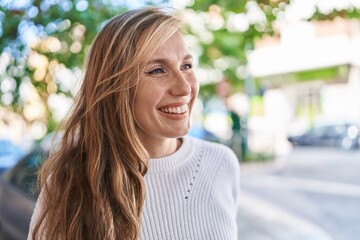 Poster - Young blonde woman smiling confident looking to the side at street