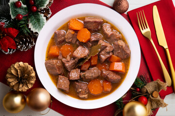 Canvas Print - Beef stew with carrots. Traditional tapa from the central area of Spain.. Christmas food served on a table decorated with Christmas motifs.