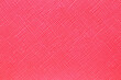 Seamless plastic texture background. Close-up of a detail from a red surface of a cosmetic bag. Beautiful backdrop. Macro.