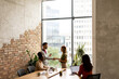 © BGStock72 - Young multiethnic startup team working by the brick wall in the industrial style office