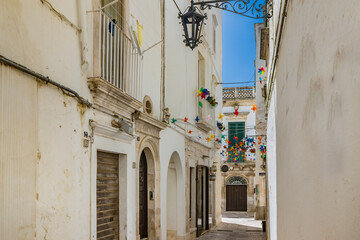 Wall Mural - Martina Franca, Taranto, Puglia, Italy. Village with baroque architecture. The narrow alleys of the city and the buildings with their characteristic balconies. Blue sky on a sunny day in summer.