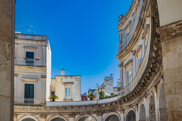 Wall Mural - Martina Franca, Taranto, Puglia, Italy. Village with baroque architecture. The beautiful Piazza Plebiscito, with its characteristic portico. Blue sky on a sunny day in summer.