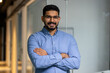 © Liubomir - Businessman with crossed arms smiling and looking at camera, portrait of happy male worker inside office, boss in glasses and shirt, happy with achievement results, proud and confident.