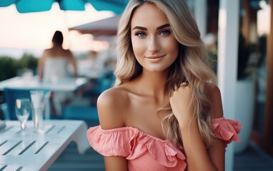 A beautiful girl sits on the terrace of an expensive restaurant on the beach