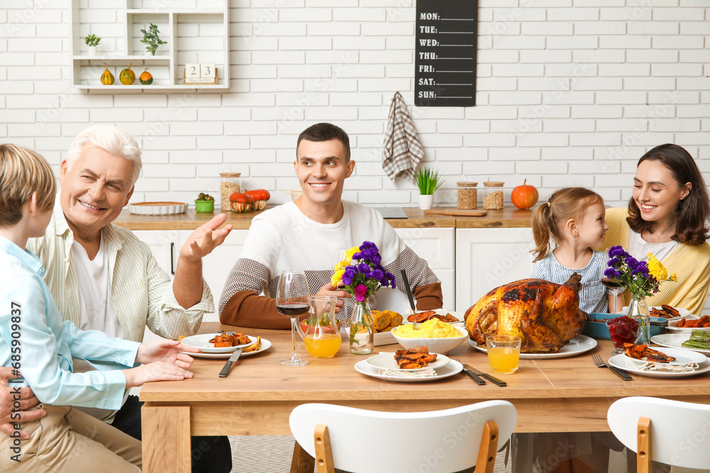 Happy family having dinner at festive table on Thanksgiving Day