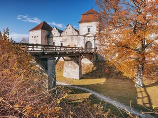 view to bridge and entrance to castle in autumn day in vintage edit