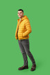 © Pixel-Shot - Young man in yellow stylish puffer jacket on green background