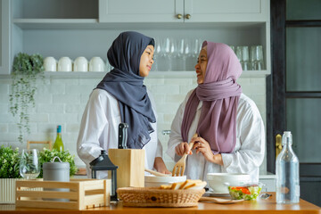 Sticker - Cute Girl And Her Muslim Mom In Hijab Preparing Pastry For Cookies In Kitchen, Baking Together At Home. Islamic Lady With Daughter Enjoying Doing Homemade Pastry