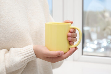 Sticker - Woman holding yellow mug indoors, closeup. Mockup for design