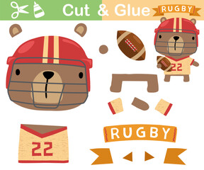 Canvas Print - Vector illustration of cartoon bear in rugby player uniform with ball. Paper game for kids. Cut and glue