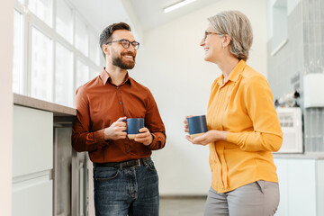 Wall Mural - Overjoyed business colleagues drinking coffee together in modern office