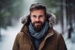 Portrait of a handsome bearded man in a snowy forest. Winter fashion.