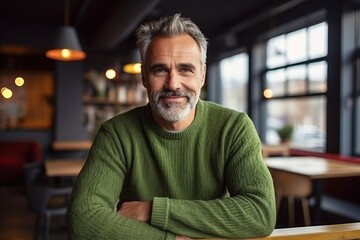 Wall Mural - Portrait of a senior man sitting in a cafe, looking at camera.