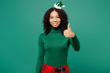 Merry Cool Little Kid Teen Girl Wear Turtleneck Hat Casual Clothes Posing Showing Thumb Up Like Gesture Isolated On Plain Green Background Studio Portrait. Happy New Year Celebration Holiday Concept.