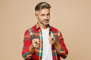 Adult man he wear red shirt white t-shirt casual clothes point index finger camera on you motivating encourage isolated on plain pastel light beige color background studio portrait. Lifestyle concept.