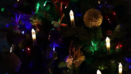 Sticker - Christmas tree with decorations and garland at night close-up.