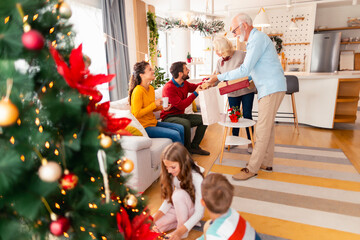 Wall Mural - Multi-generation family exchanging Christmas gifts at home