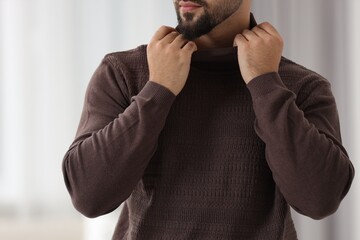 Wall Mural - Man in stylish sweater against blurred background, closeup