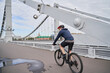 © nuclear_lily - Man riding on bicycle across the bridge in the city.