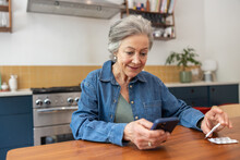 Senior woman at home using a smartphone to order prescription drugs online