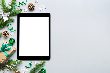 Wall Mural - Digital tablet mock up with rustic Christmas decorations for app presentation top view with empty space for you design. Christmas online shopping concept. Tablet with copy space on colored background