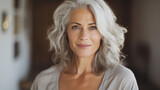 Fototapeta  - Beautiful aged mature woman with healthy face skin, grey hair and happy smile on light interior background. Skin care, natural beauty, cosmetology concept.