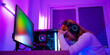 Game over you lose. Angry Asian gamer wearing gaming headphones playing joystick console video game on computer PC neon light at home feeling sad disappointed about game losing, player unhappy E-Sport