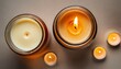 two candles burning soy way candle in an amber glass jar and a cream colored tea light over background top view generative ai