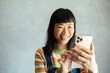 © Davor - Close up smiling woman touching smartphone