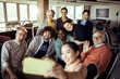© Davor - Diverse group of colleagues taking a selfie in a bright office space