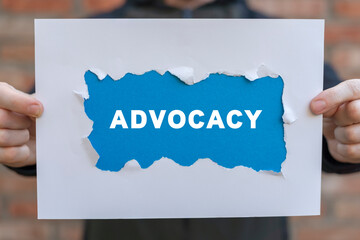 man holding white and blue sheets of paper with word: advocacy. business advocacy and lawyer consult