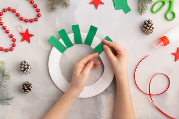 Wall Mural - Christmas wreath from color paper with children. Step by step instructions. Handmade DIY new year holiday decoration project.