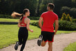© New Africa - Healthy lifestyle. Couple running in park on sunny day, back view