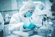 A Scientist virus researcher in Forensic laboratory in a protective suit working on making virus antidote to cure the virus from pandemic and quarantine. Scientist in Forensic Lab.