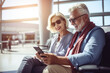 © The other house - Portrait of happy senior couple tourists waiting to checkin in the airport. Reviewing the trip itinerary on the smartphone
