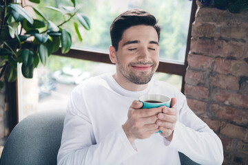 Wall Mural - Photo of dreamy funky young guy wear white shirt closed eyes enjoying cacao flavor aroma indoors apartment room