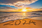Fototapeta Mapy - Sea sunrise of first new day for 2024 year text on beach sand