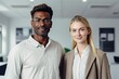 © Malynka - Portrait of two business people standing in an office, Two happy professional business people team woman and man workers discussing financial market data standing at corporate office meeting