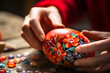Close-up of hands delicately painting an Easter egg with folk designs.