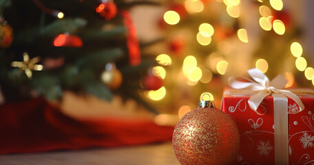 Wall Mural - A closeup of a Christmas gift by a Christmas tree, bokeh