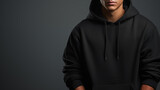 Fototapeta  - Beautiful male in a black hoodie posing. Warm oversized hoodie with an hood. Stylish trendy hipster bow. Trying on clothes in a store. Youth subculture. Fashion clothing. Generated AI