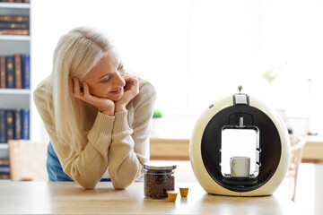 Sticker - Mature woman with modern coffee machine in kitchen