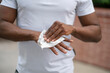a holding antibacterial wet napkin to clean and disinfect dirty hands outdoors